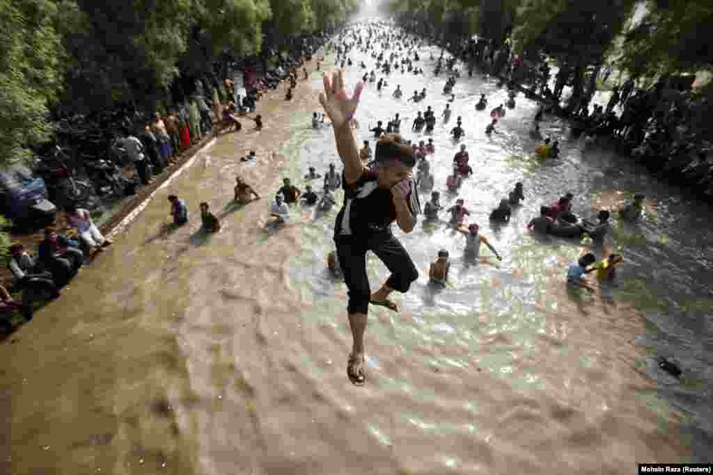 A boy jumps into a canal to cool off in Lahore, Pakistan, as temperatures reached 43 degrees Celsius.