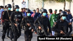 Police officers wear masks amid coronavirus fears as they guard Pakistan Super League cricket matches outside the National Stadium in Karachi on March 12.