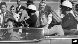 Președintele american John Kennedy în mașină lângă soția lui, Jacqueline, înainte de asasinat - 22 noiembrie 1963.