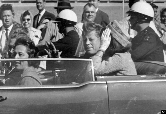 Presidenti John F.Kennedy duke përshëndetur qytetarët nga vetura e tij, pothuajse një minutë para se të qëllohej për vdekje më 22 nëntor 1963.