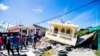 Haiti -- People stand next to a house destroyed following a 7.2 magnitude earthquake in Les Cayes, Haiti August 14, 2021. REUTERS/Ralph Tedy Erol NO RESALES. NO ARCHIVES TPX IMAGES OF THE DAY