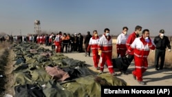 Spasioci odnose tela žrtava iz ukrajinskog aviona koji se srušio nedaleko od Teherana, 8. januara 2020.