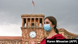 A woman wearing a protective face mask walks in central Yerevan.