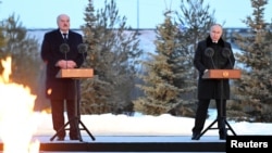 Russian President Vladimir Putin (right) and Belarusian President Alyaksandr Lukashenka attend a ceremony to unveil the memorial complex to Soviet civilians killed during World War II, as part of commemorative events marking 80 years since Leningrad siege was lifted, in the village of Zaitsevo in the Leningrad region on January 27.