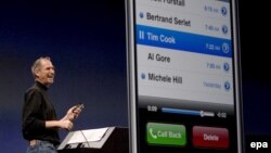 Steve Jobs duke e prezantuar një model të iPhone-it.
