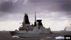 At Sea -- HMS Duncan (C) monitors the Russian battle cruiser Peter the Great (L) and aircraft carrier Admiral Kuznetsovon as they proceed through the North Sea, October 20, 2016