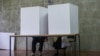 Serbia - People votes in a voting booth at a polling station in Belgrade on June 21, 2020