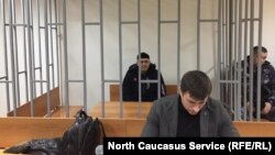Оюб Титиев (на дальнем плане) в суде.