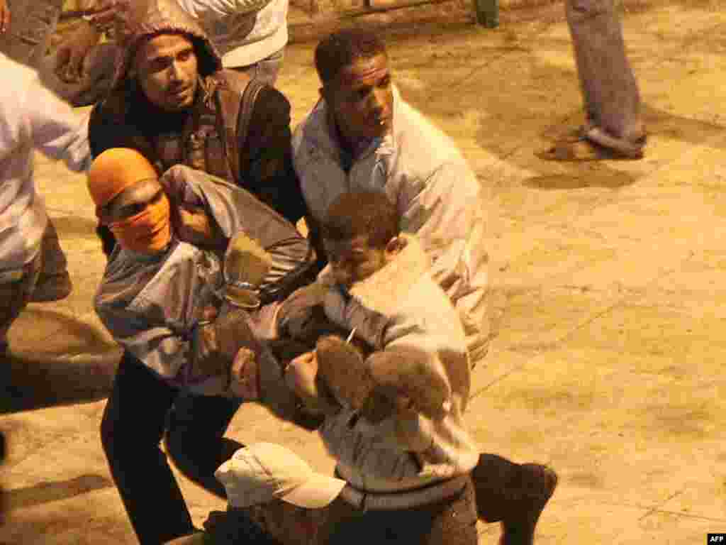 Demonstrators carry an injured protester during clashes with anti-riot police in Suez January 27.