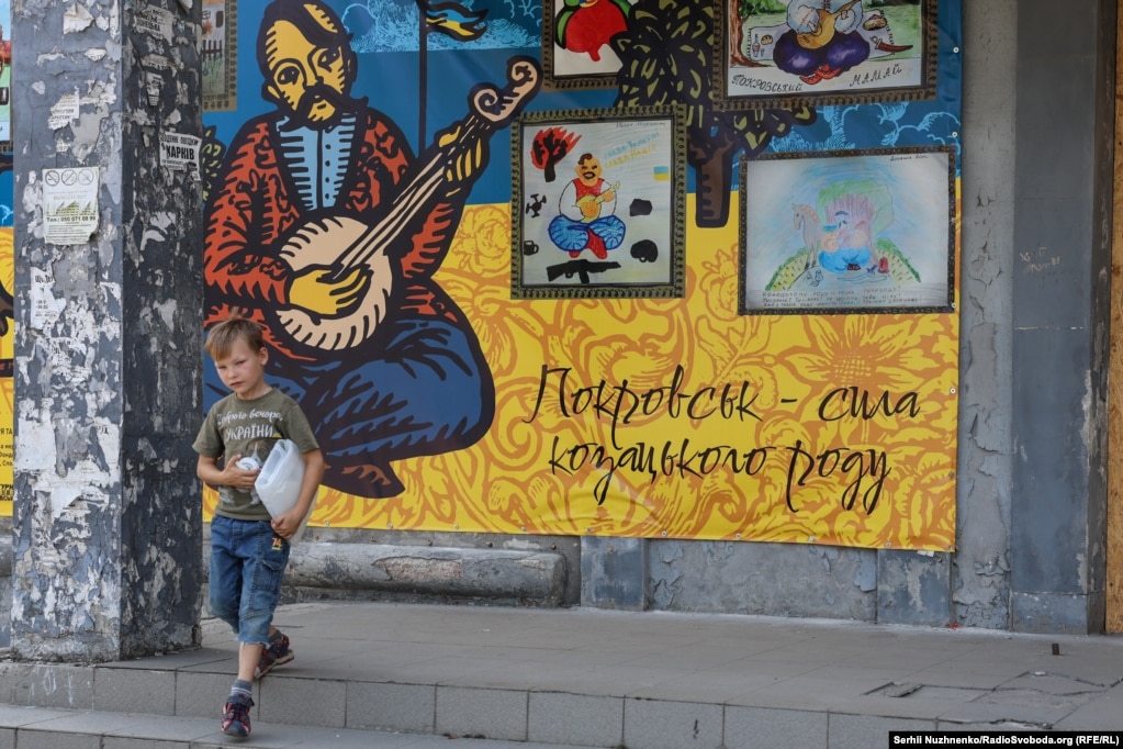 Një fëmijë pranë një murali në Pokrovsk.