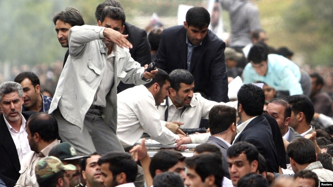 Bodyguards reacted to a burst of sound behind the entourage of President Mahmud Ahmadinejad (center) as he was welcomed to Hamedan on August 4.