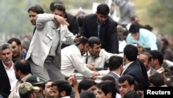 Bodyguards reacted to a burst of sound behind the entourage of President Mahmud Ahmadinejad (center) as he was welcomed to Hamedan on August 4.