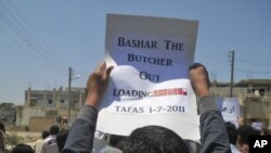A protester holds up a placard during a demonstration against the Assad regime in village of Tafas on July 1.