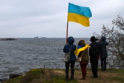 People get ready to welcome three Ukrainian Navy ships to a port in Ochakiv, in Ukraine's southern Mykolaiv region, on November 20.