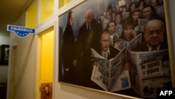 (FOTO) Un tablou fantezist cu președintele rus Vladimir Putin și alți politicieni citind „Novaia Gazeta”, pe perete în redacția din Moscova, pe 24 martie 2021.