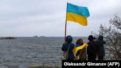 People get ready to welcome three Ukrainian Navy ships to a port in Ochakiv, in Ukraine's southern Mykolaiv region, on November 20. 