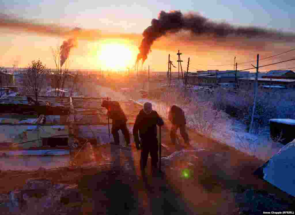 Workers pull apart a house in Khandyga, Russia, on February 2. The shifting ground caused by the uneven thawing of permafrost each summer causes buildings like this Soviet-era apartment house to sag and collapse. Find out more about people who work in Russia&rsquo;s Sakha Republic through winter temperatures that regularly drop below -50 degrees Celsius in our feature story,&nbsp;The Coldest People on Earth. (Amos Chapple, RFE/RL)