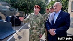 Belarusian President Alyaksandr Lukashenka (right) inspects police vehicles as he visits the Interior Ministry special forces base in Minsk on July 28. 