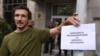 Протестиращ в София пред сградата на Комисията за противодействие на корупцията с надпис "Комисия за противодействие на борбата с корупцията"