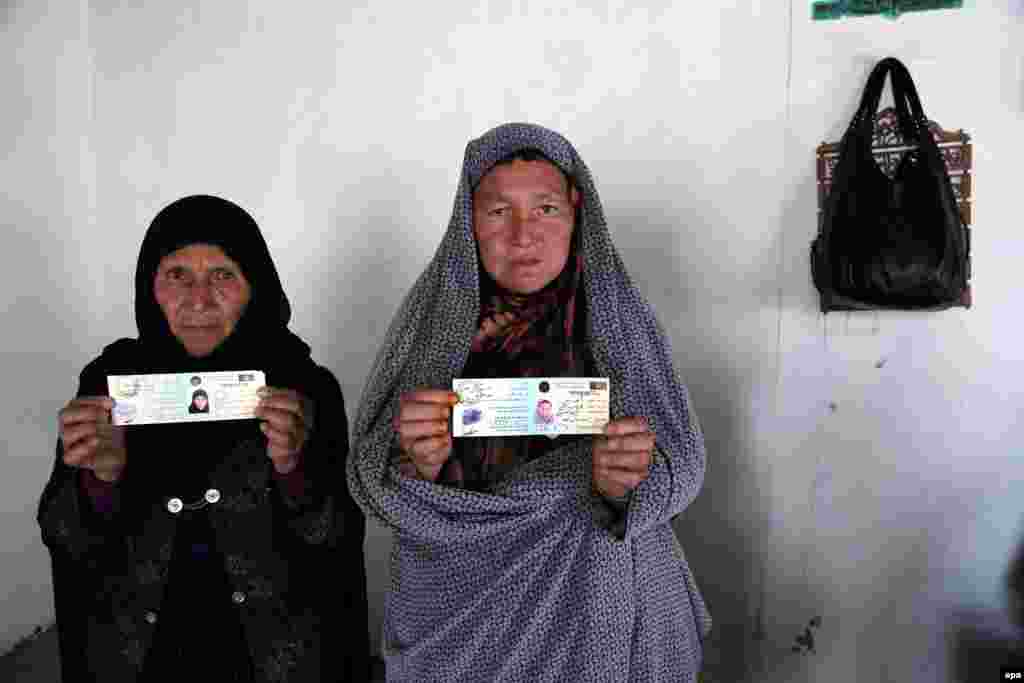 Afghan women show their voting cards at a voter registration center in Kabul, Afghanistan, on March 31. (epa/S. Sabawoon)&nbsp;