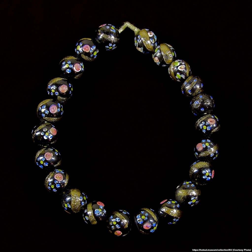 Венеційське намисто. Нанизане з чорних скляних намистин, оздоблених золотистими скісними смужками і дрібненькими голубими та червоними квітками. З колекції Національного музею народного мистецтва Гуцульщини та Покуття імені Й.Кобринського