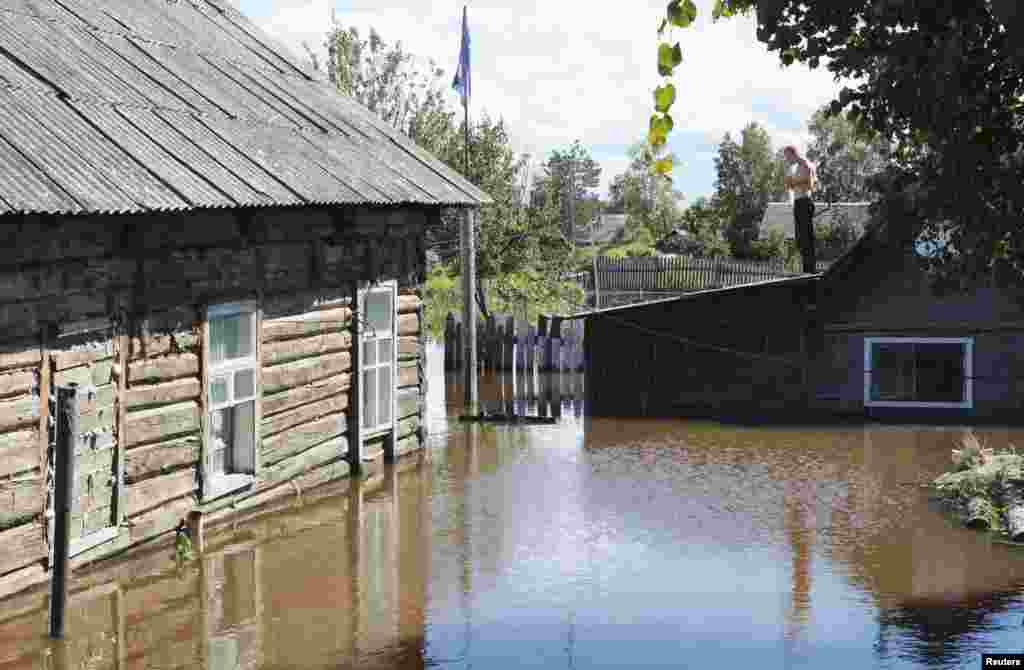 A local resident stands on the roof of a building in the flooded settlement of Krasnaya Rechka on the outskirts of the Far Eastern city of Khabarovsk, Russia. (Reuters/Vladimir Barsukov)