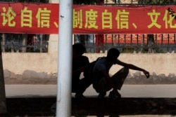 Коммунистическая символика и пропаганда окружает жителей Синьцзяна постоянно (как и всех остальных китайцев). Студенты у входа в одну из областных школ. Лозунги гласят: "Постоянный самоконтроль! Постоянный культурный контроль!".