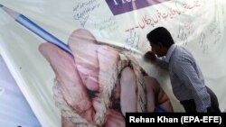 A Pakistani journalist signs a banner during a protest against the deteriorating security situation for journalists in the country and to mark World Press Freedom Day in Karachi in May 3.
