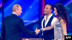 Russian Prime Minister Vladimir Putin (left) shakes hands with Azerbaijan's entry in the 2009 Eurovision contest, AySel and Arash, during rehearals in Moscow.