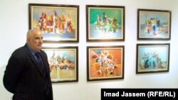 عبد الجبار العتاب امام عدد من لوحاته 