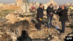 TV journalists stand amid the wreckage after a Ukrainian plane crashed in Iran, possibly downed by a missile.