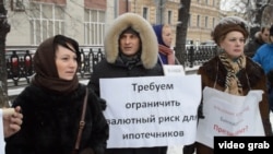 Ипотечники стоят в Москве с плакатом, требующим ограничить валютный риск для ипотечников.