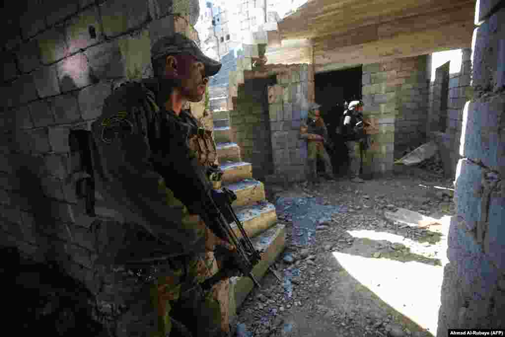 Members of the Iraqi forces advance towards the Dindan neighborhood on February 25.