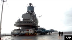 A file photo of the Russian aircraft carrier, the Admiral Kuznetsov, docked in the Syrian port of Tartus, where Moscow will now be expanding operations. 