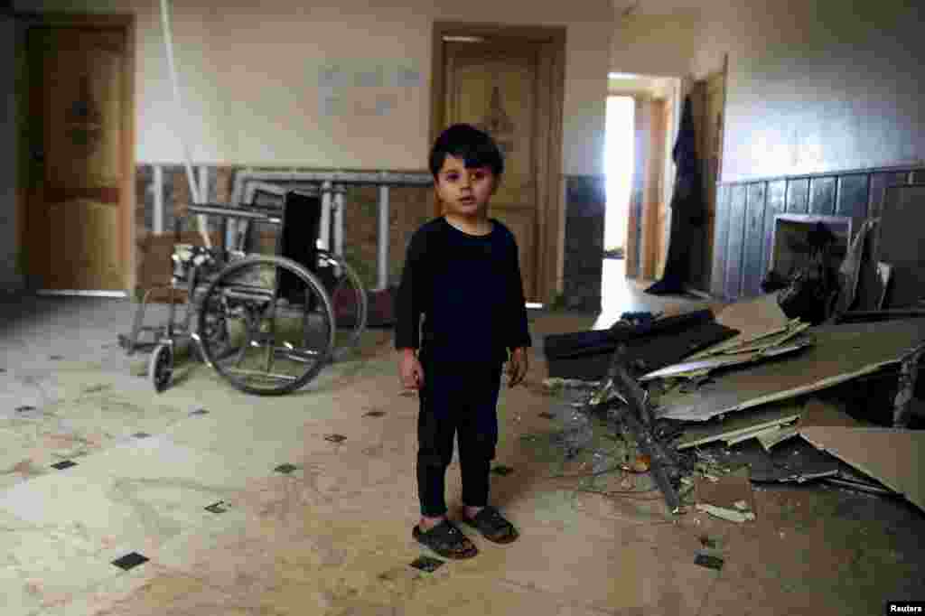 A Syrian boy who was evacuated with others from two rebel-besieged towns in northwestern Idlib Province is seen standing inside a hospital that was struck by an explosion on the outskirts of the Sayeda Zeinab district, south of Damascus. (Reuters/Omar Sanadiki)