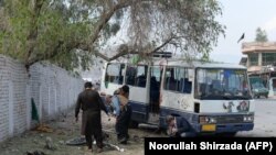 Afghan policemen inspect the scene after a deadly blast in Jalalabad on March 19. 