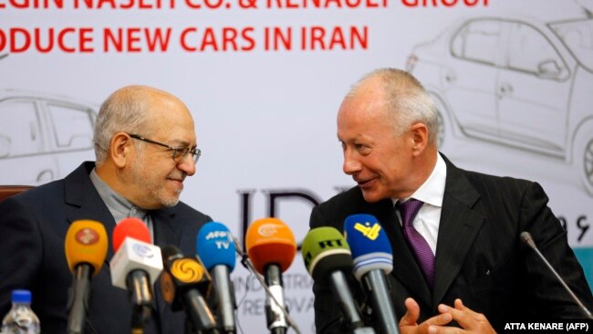 Thierry Bollore (R), deputy director of Competitiveness at Renault, and Iranian Minister of Industry Mohammad Reza Nematzadeh attend a press conference following the signing of a deal in Tehran on August 7, 2017