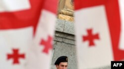 A Georgian policeman watches a mid-May opposition rally from near the parliament building.