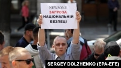 Учасник акції біля будівлі Нацради з питань телебачення і радіомовлення з вимогою скасувати ліцензію телеканалу NewsOne. Київ, 9 липня 2019 року