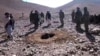 A RFE/RL video grab shows Afghan men stoning Afghan woman Rokhsana (C, in hole) to death in Ghalmeen, Afghanistan's Ghor province. Local officials say the incident happened in October. 