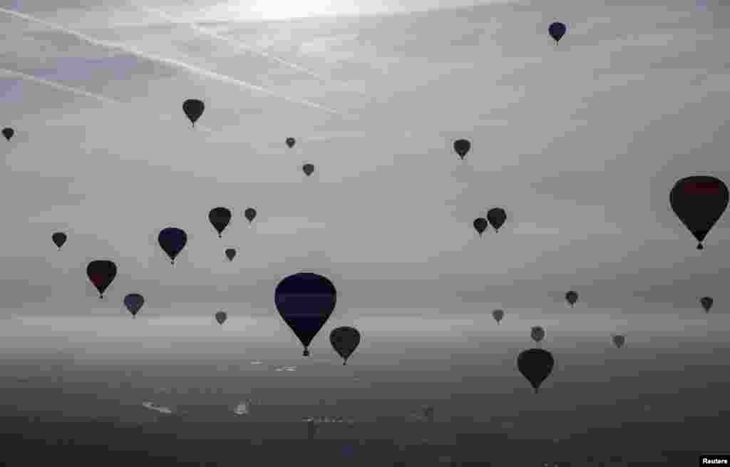 Hot-air balloons rise into the sky at the International Balloon Fiesta near Bristol in western England. (Reuters/Neil Hall)