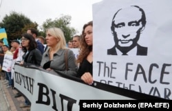 Ukrainian activists hold up anti-Russian and ant-Putin placards and banners as they join a protest in front of Russian Embassy in Kyiv last month.