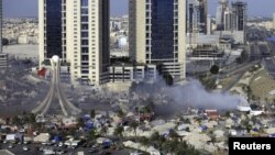 Smoke rises as Gulf Cooperation Council forces move in to Pearl Square to evacuate antigovernment protesters in Manama on March 16, 2011.