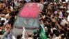 Supporters of former Pakistani Prime Minister Nawaz Sharif crowd around his car near Islamabad on August.