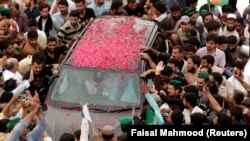 Supporters of former Pakistani Prime Minister Nawaz Sharif crowd around his car as his convoy enters Rawalpindi on August 9.