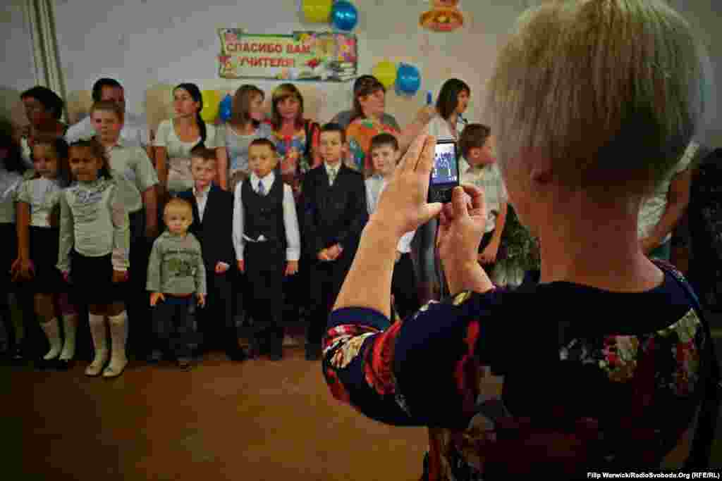 Мама фотографує свою дитину, поки інші терпляче чекають