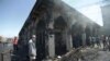 People gather at the site of a suicide attack at the entrance of the Shi'ite Mausoleum of Sayid Muhammad bin Ali al-Hadi in Balad, north of Baghdad, on July 8.