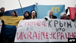 People hold signs reading "Crimea is Ukraine" during a rally on Independence Square in central Kyiv on March 1.