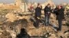 TV journalists stand amid the wreckage after a Ukrainian plane crashed in Iran, possibly downed by a missile.