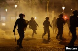 Policia franceze në Paris gjatë festimeve të tifozëve të futbollit.